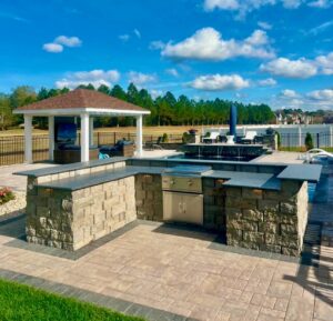 Outdoor kitchen with stone countertops and covered pergola