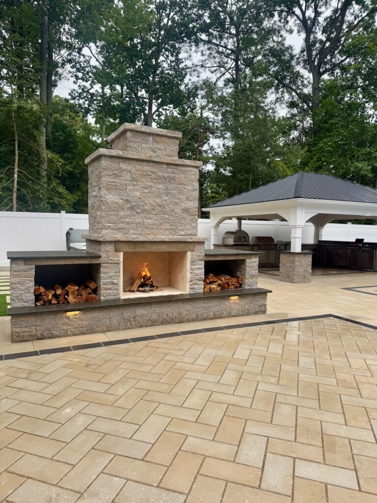 Outdoor living space with stone fireplace and paver patio