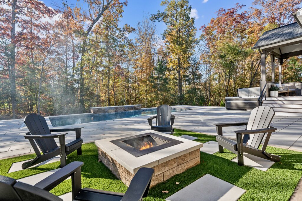 Elevated stone fire pit with built-in seating and paver patio