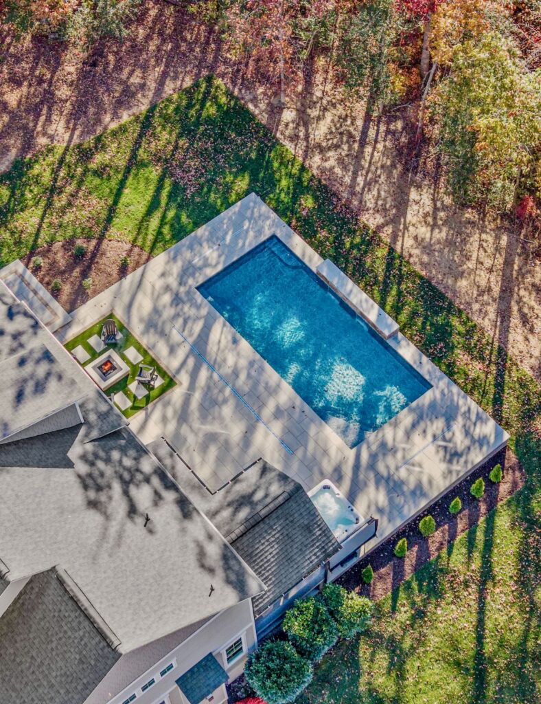 Aerial view of kidney-shaped inground pool with stone waterfall feature