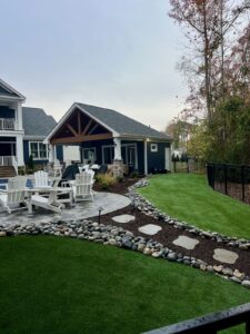 Landscaped backyard with river rock beds and lawn