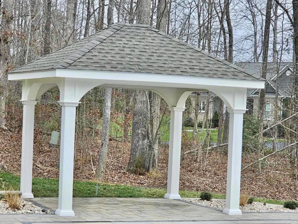 White vinyl pavilion in wooded backyard setting