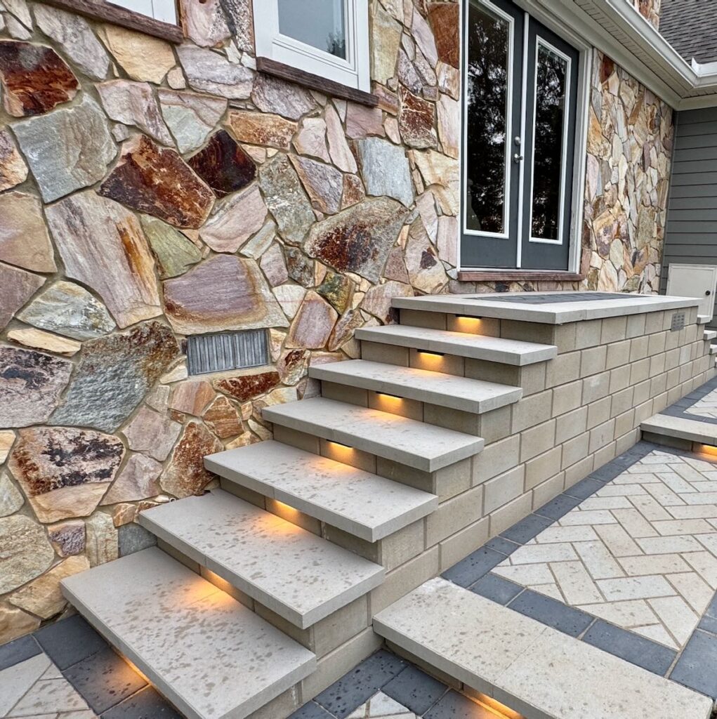 Segmented retaining wall with stone steps and decorative boulders